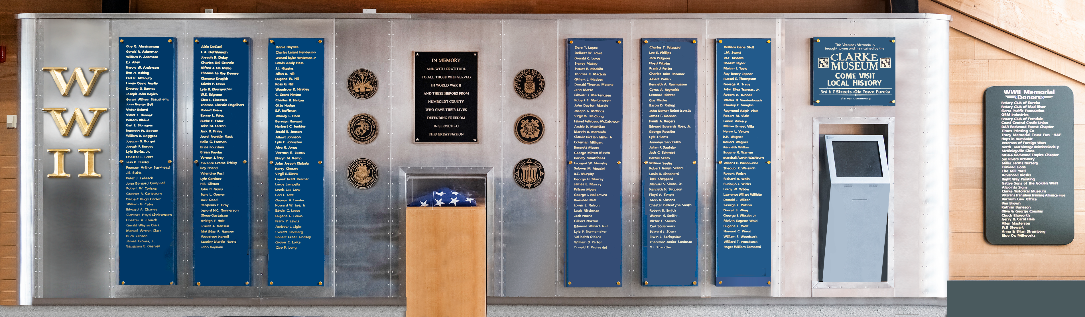A memorial with engraved panels and a folded flag display.