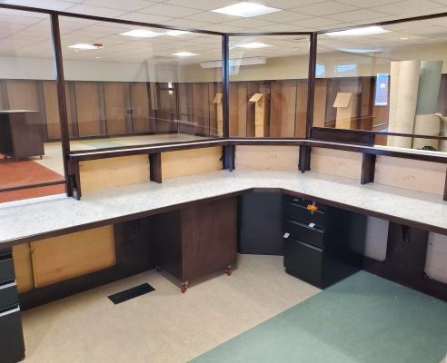 Inside, the service desk is not quite done, and looks out at unfinished shelves.