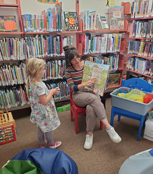Ms. Julia reading to a child at the Blue Lake Library