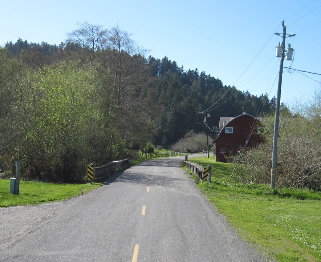 Williams Creek Bridge with red barn on right side of road