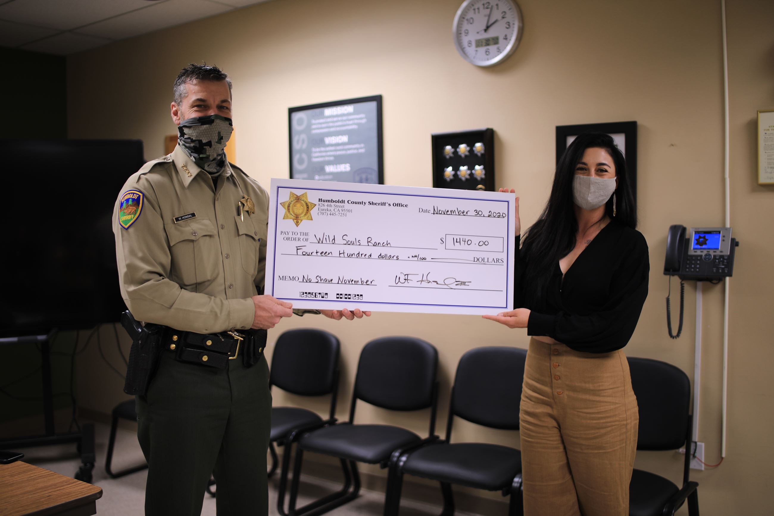 Sheriff Honsal and a Wild Souls Ranch representative take a photo with a big check